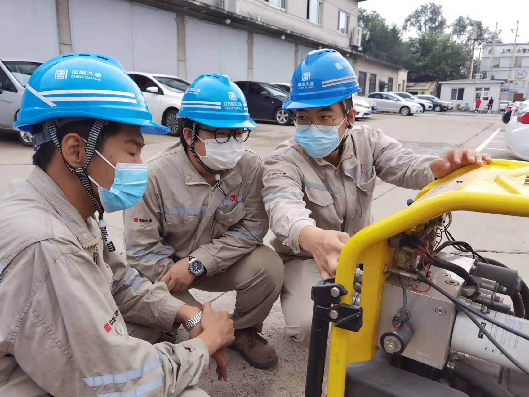 1662358534830062556.jpg 華翔(右一)正在為班組同事培訓(xùn)大型設(shè)備使用技巧和保養(yǎng)方法.jpg